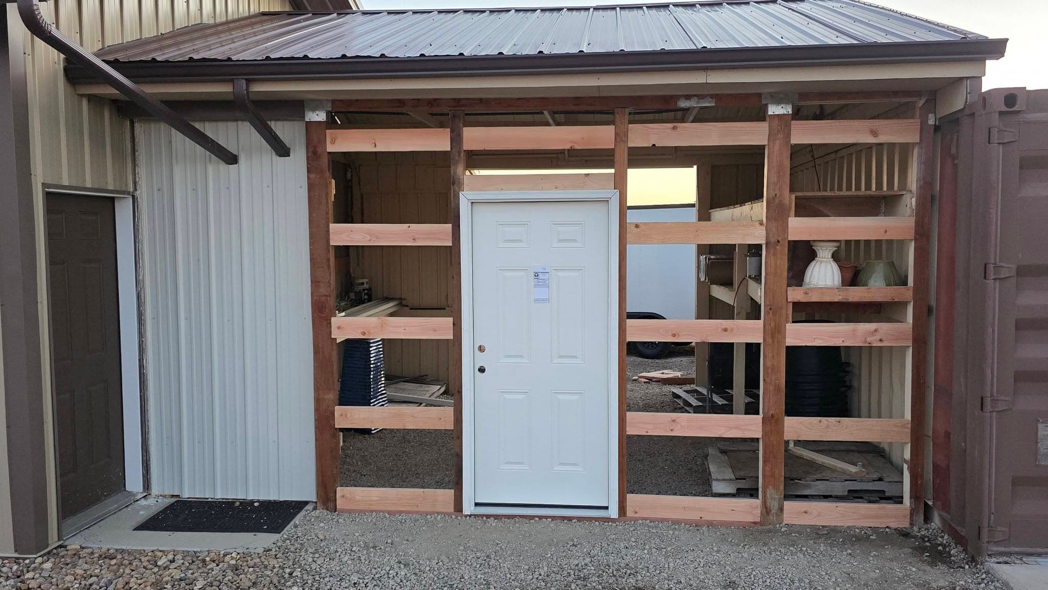 Custom wooden storage shed with metal roof and built-in shelving
