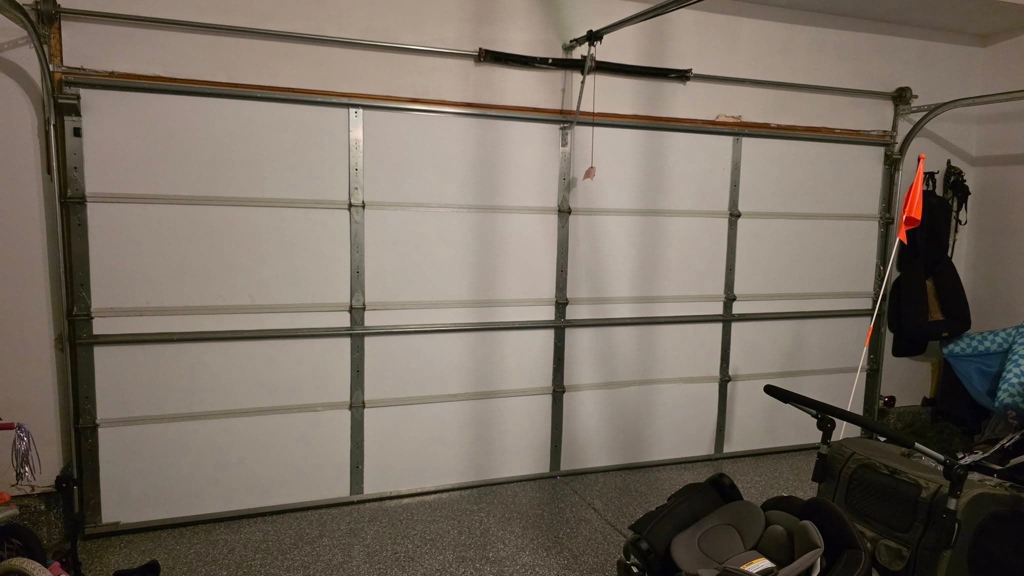 A newly installed white garage door with aluminum frame